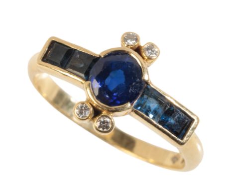 A SAPPHIRE AND DIAMOND RING the central oval cut sapphire collet-set with two calibre-cut sapphires either side and accented 