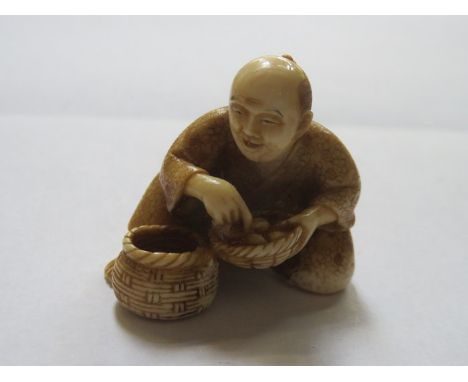 HEAVILY CARVED ANTIQUE IVORY NETSUKE DEPICTING A SEATED GENT,