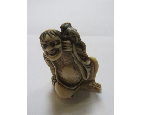 HEAVILY CARVED ORIENTAL IVORY NETSUKE OF A SEATED FIGURE WITH A FROG, APPROXIMATELY 5cm HIGH