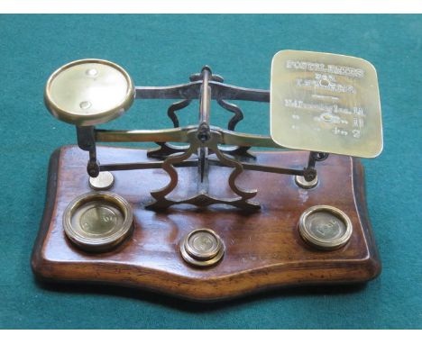SMALL SET OF VINTAGE BRASS POSTAL SCALES ON MAHOGANY SUPPORT AND WITH FOUR WEIGHTS