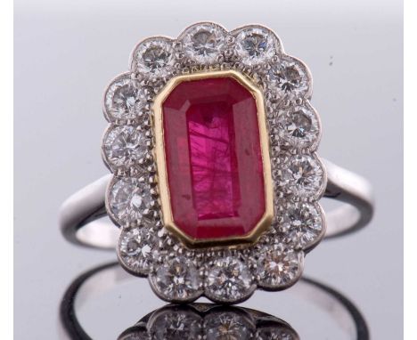 An 18ct ruby and diamond ring, the octagonal step cut ruby, approx. 11 x 6 x 4.1mm, collet mounted in yellow gold and surroun