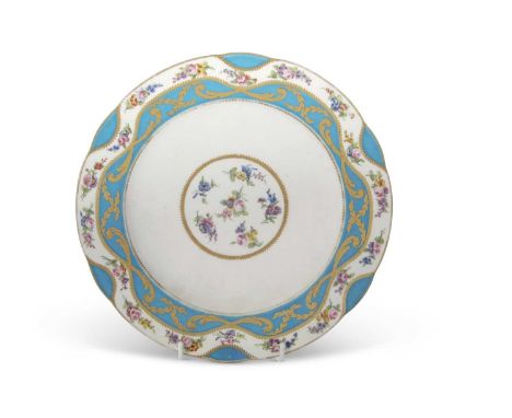 An 18th Century Sevres plate the centre decorated with scattered floral sprays within a gilt border and the plate with wavey 