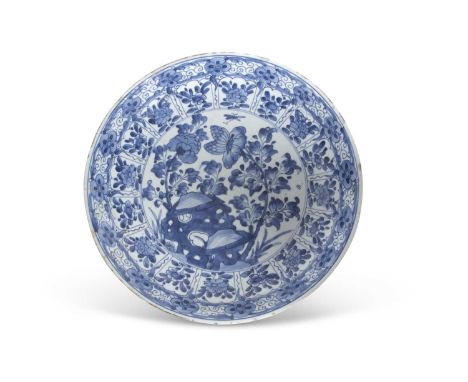 A large Chinese porcelain charger Kangxi period decorated in blue, the centre with floral sprays and insects, with further fl