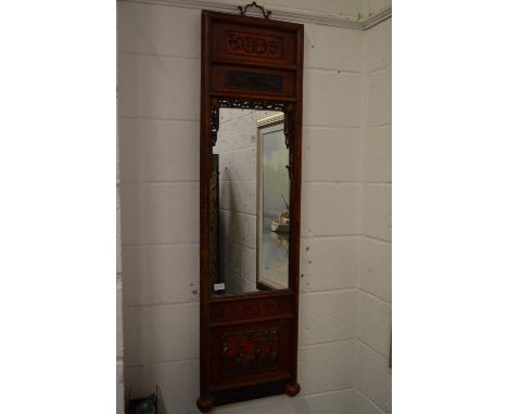 A Chinese mirror with decorative frame.
