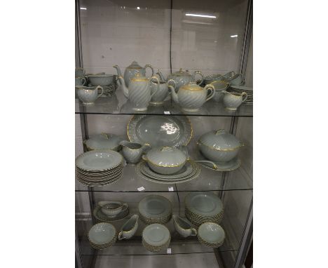 A comprehensive Clarice Cliff dinner, tea and coffee service, green ground with gilt decorated shaped rims.