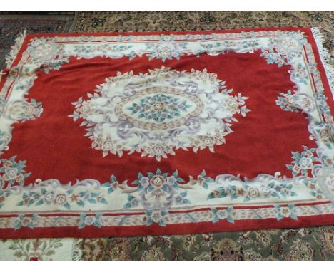 A Chinese red and floral carpet, 106" x 73" plus matching rug