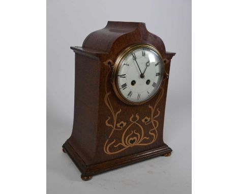 An Art Nouveau oak cased mantel clock, having brass and ebony foliate inlay, the white enamel dial signed Asprey, and showing
