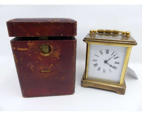 A lacquered brass carriage clock having white enamel dial showing Roman numeral markers, and visible platform escapement, hei