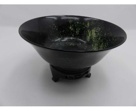 A Chinese spinach jade bowl, dia.18cm, upon a carved hardwood standLate 20th century (1970s-1908s)