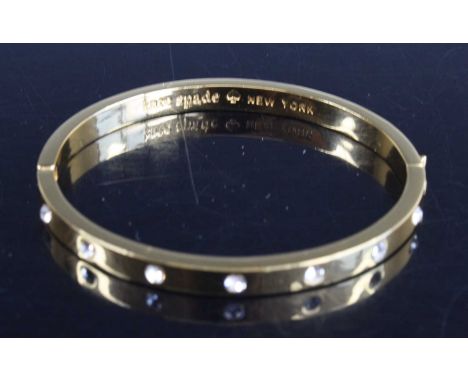 A Kate Spade of New York gilt metal and enamel hinge bangle, together with one other paste set example by the maker, and a gi