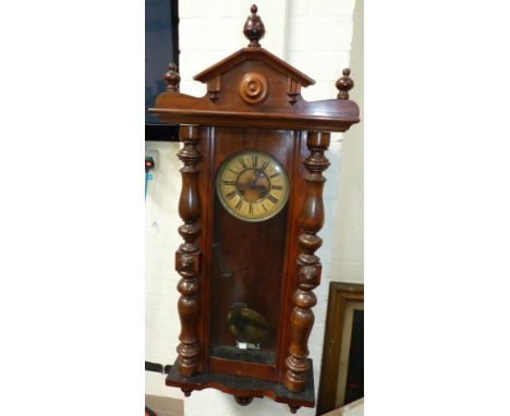 A 19th century walnut cased Vienna wall clock with turned finials and architectural pediment, half turned side pillars, and s