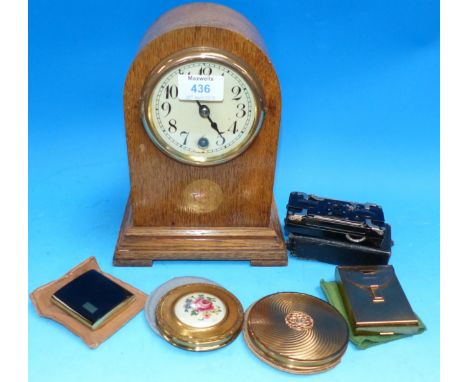 An Edwardian oak inlaid mantel clock; an "Ensignette” by Houghton; 4 compacts