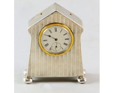 Silver cased mantle clock with engine turned line decoration to front, sat on four bun feet, rubbed hallmarks.     