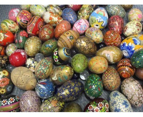 A large quantity of painted papermache and wooden eggs housed in a large glass storage jar with lid, together with a small qu
