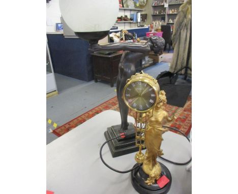 A late 20th century table lamp together with a gilt clock suspended from a gilt figure 