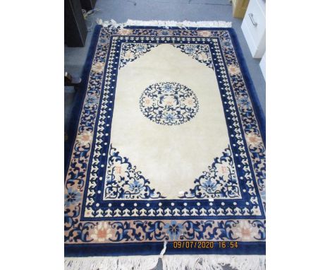 A cream and blue ground Chinese style carpet with fringe 