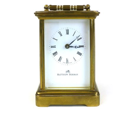 A brass four pane carriage clock by Matthew Norman, serial number 1754, eleven jewel movement. h. 12 cm excluding handle. CON