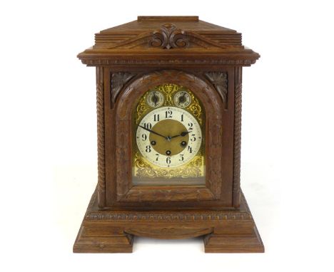 An oak cased mantle clock, with chime/silent and fast/slow subsidiary dials, on a brass Junghans striking movement. h. 40 cm.