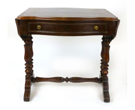 A mahogany sofa table, 19th century, of serpentine form with a single frieze drawer, on carved and turned baluster supports a