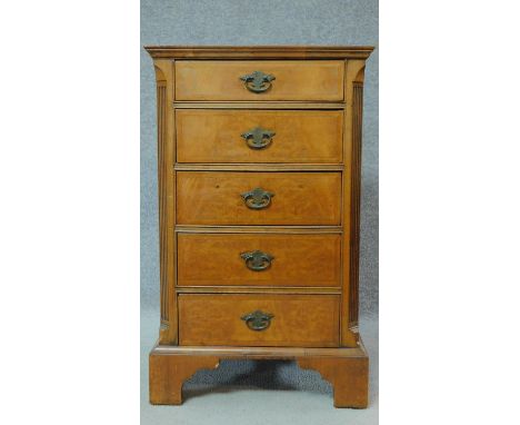 A Georgian style burr walnut bedside cabinet fitted with five short drawers, raised on bracket feet. H.78 W.48 D.49cm 