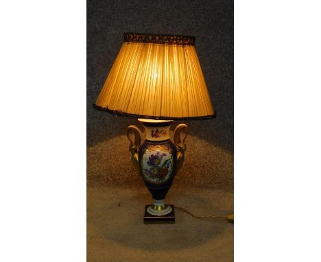 A porcelain hand painted converted vase to lamp with floral design and swan gilt painted handles, by Limoges. H.58cm