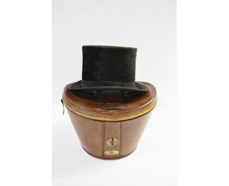 VINTAGE LEATHER CASED TOP HAT a vintage leather hat box with brass lock and red velvet interior, with a black top hat by Chri