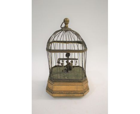 SINGING BIRD AUTOMATON a bird cage with a bird inside that moves and sings, operated by a wound mechanism from the base. In w