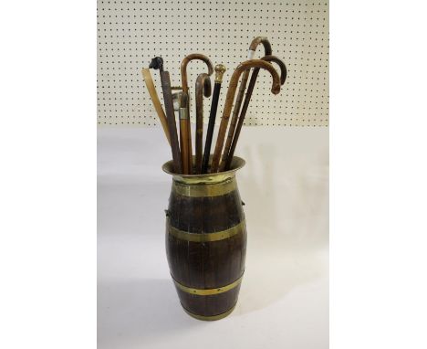 BRASS BOUND STICK STAND &amp; VARIOUS WALKING STICKS an oak and brass bound stick stand with brass top (55cms high), also wit