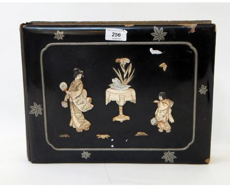 A lacquered papier mache postcard album with applied bone and mother-of-pearl decoration with inset metalwork, the fabric pag
