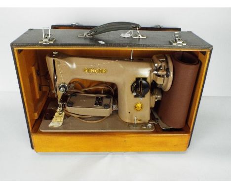 A vintage Singer sewing machine in carry case.