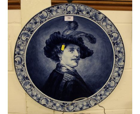 A large Delft blue and white pottery charger depicting a portrait of a gentleman 