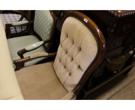 A wooden and button back elbow chair 