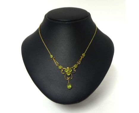 A Victorian gold and peridot necklace, the openwork scroll front milligrain collet set with mixed cut stones, back chain stam