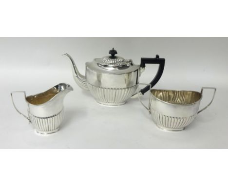 An electroplated three piece tea service, of oval half fluted form.