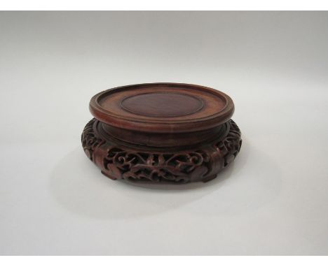 A 19th Century Chinese carved rosewood display stand for a vase. 20cm diameter 