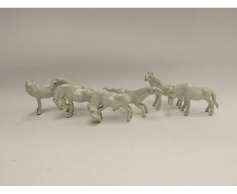 A set of seven miniature white ceramic horses 