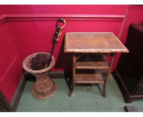 A bamboo table with a wicker umbrella stand and two carved African items 