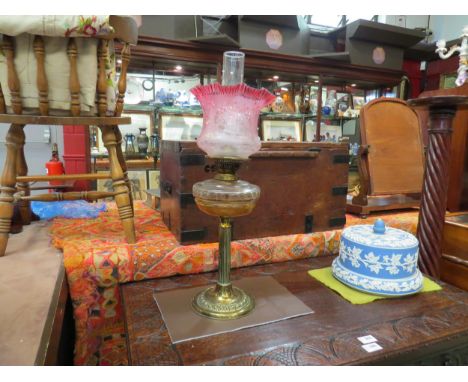 A Victorian oil lamp with cut glass reservoir and etched cranberry glass shade 