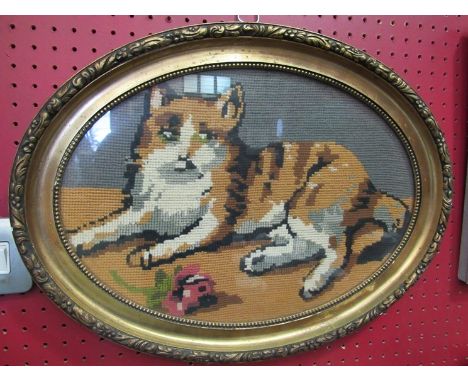An early 20th Century wool tapestry depicting a recumbant tabby cat with flower in an oval gilt frame, 28cm x 38cm 