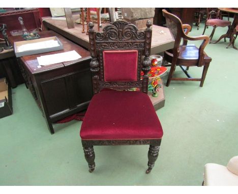 A late Victorian carved oak chair with Grecian bowl and acanthus leaf decoration the turned fore legs on ceramic castors 