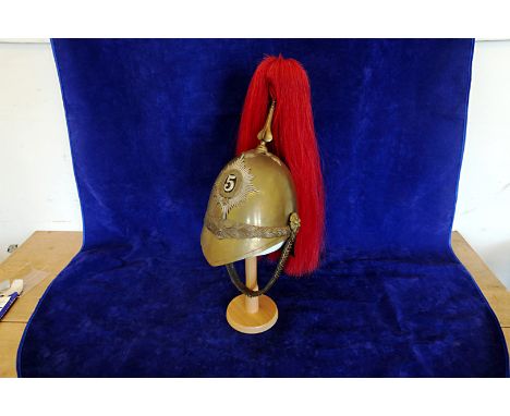 A brass plumed cavalry officer's helmet bearing the emblem of the Fifth Dragoon Guards. 