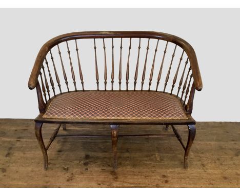 An Edwardian mahogany bench with spindle turned back and oval stuffed seat, on cabriole legs and turned stretchers (af). 44in