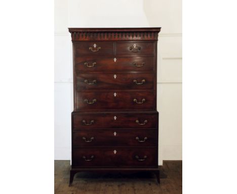 A George III mahogany chest on chest with carved pediment above two short and six long drawers with bone escutcheons, on out-