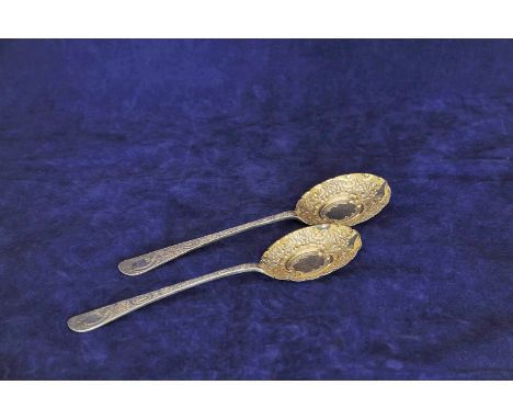A pair of late Victorian silver serving spoons with rococo scroll and stylised flower head decorated handles and matching gil
