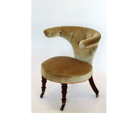 An Edwardian library chair with upholstered button back and circular seat, on turned legs and brass castors.