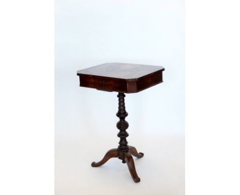 A Victorian sewing table, the hinged lid opening to reveal a compartmented interior, on a turned stem and tripod legs. 20ins 