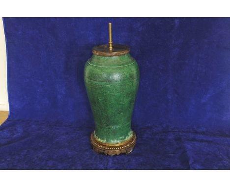 A rare 17th century Chinese Meiping vase, the green ground with all over scroll and stylised flower head incised decoration a