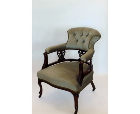 A Victorian walnut armchair with shell and acanthus leaf carved cresting rail, over-stuffed button back and over-stuffed arms