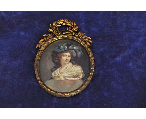 A miniature portrait of a lady wearing a blue feathered hat and lace shawl in a brass frame with pierced leaf surmount and wi