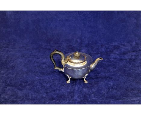 A George V silver teapot with ebony handle and finial and raised on four pad feet. Sheffield 1918. Makers M & S Ltd. 